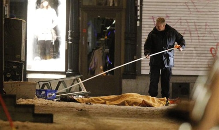 Police forensics expert at the scene of an explosion in Stockholm on Saturday. Two explosions in central Stockholm killed one person and injured two, causing panic among Christmas shoppers. Police spokeswoman Petra Sjolander said a car exploded near Drottninggatan, a busy shopping street in the center of the city.